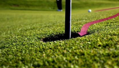 Golf ball follows an arrow showing its path to the cup before it drops in.